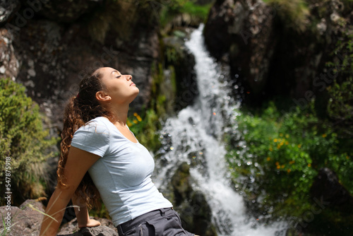 Woman relaxing and breathing in a little waterfall