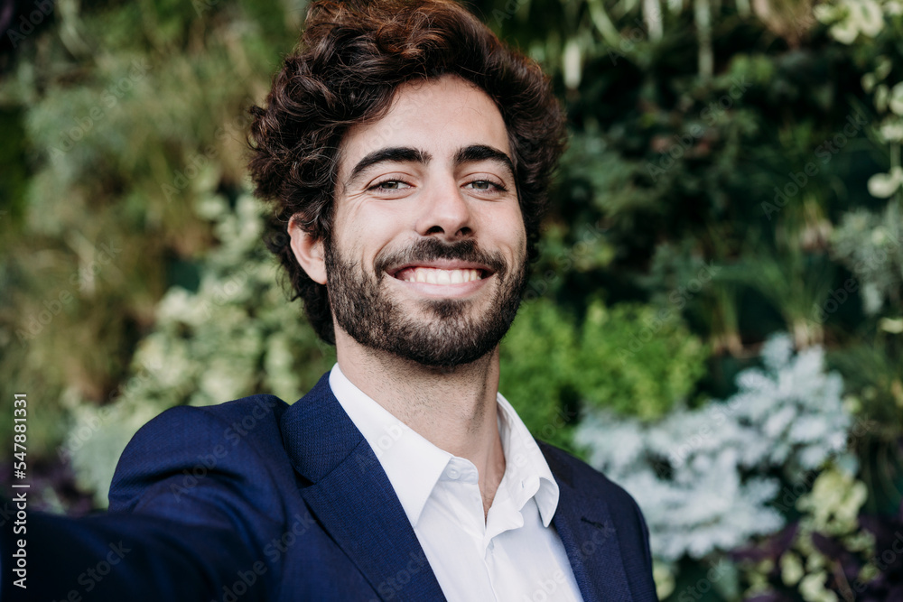 Handsome happy businessman with plants in background Handsome happy businessman with plants in background