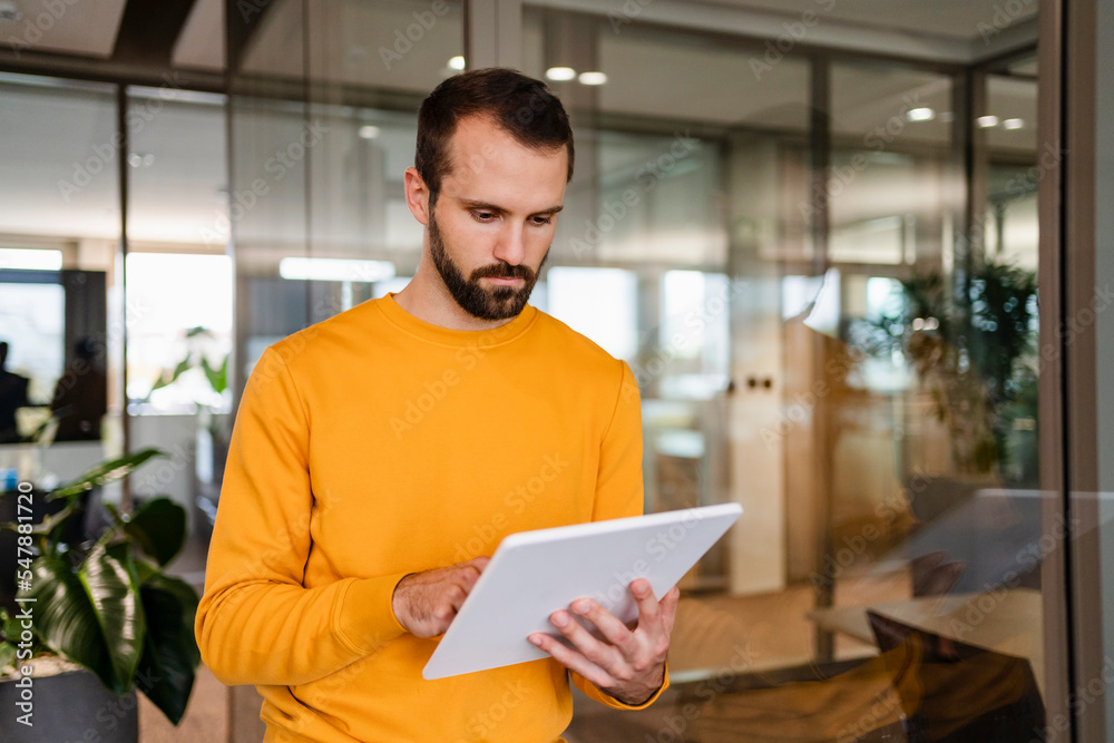 Young businessman using tablet PC in workplace Young businessman using tablet PC in workplace