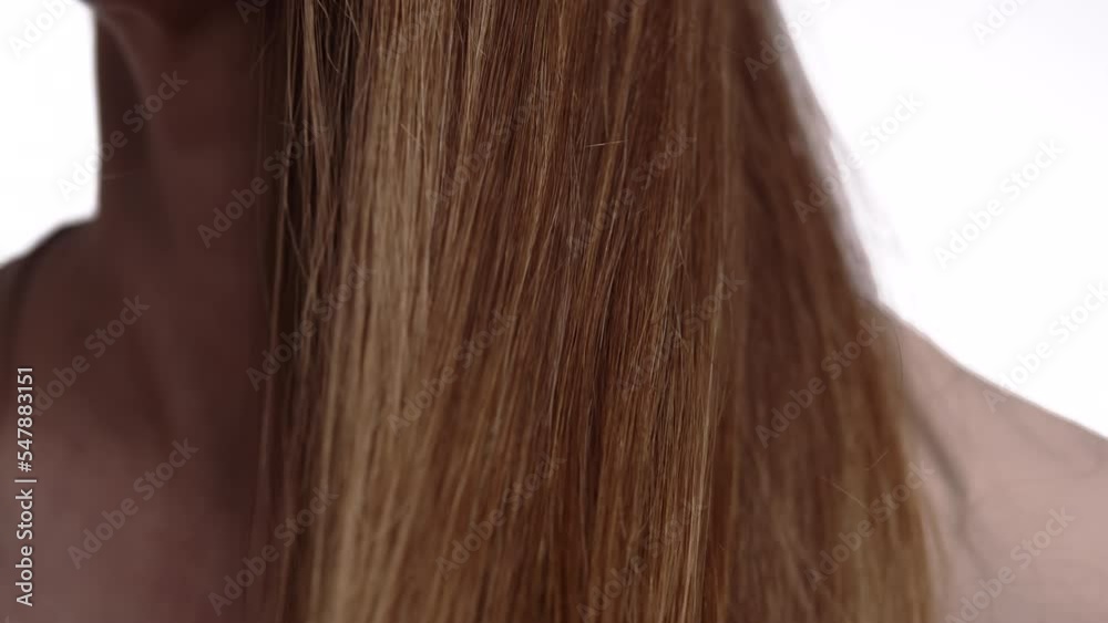 Close-up. Caucasian woman runs her hand through her hair, emphasizing the beauty and shine hair. The girl shows her healthy hair falling over shoulders. Close-up. Caucasian woman runs her hand through her hair, emphasizing the beauty and shine hair. The girl shows her healthy hair falling over shoulders.