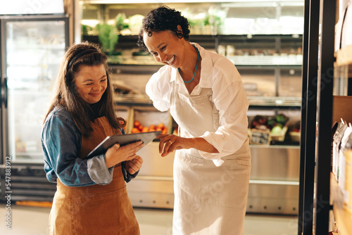 Convenience store workers using a digital tablet together