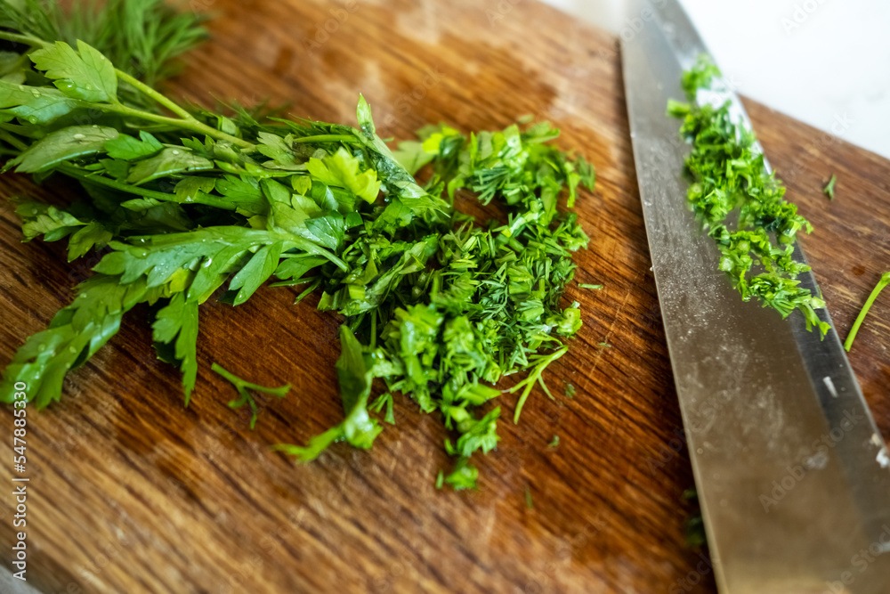 Fresh chopped parsley on a wooden cutting board. Cooking food. Fresh chopped parsley on a wooden cutting board. Cooking food.