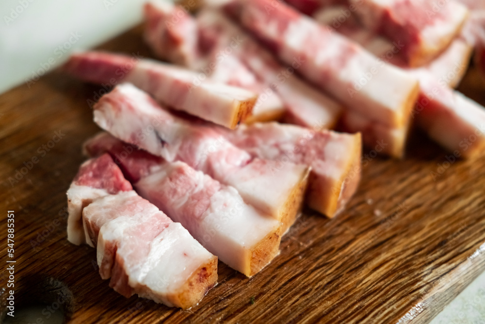 Bacon sliced on a wooden board. Salo with meat.