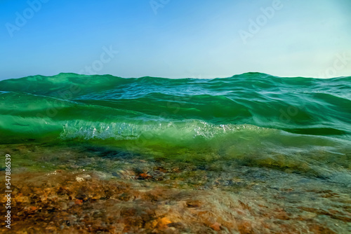 Fototapeta Naklejka Na Ścianę i Meble -  Spectacular sea waves stop steaming with separate bubbles on a bright sky background. Popular corners, all season holiday and travel concept. Copy space for design.