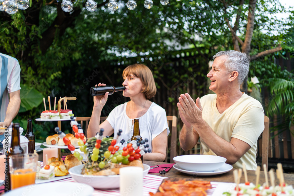 Multi-ethnic big family having fun, enjoy party outdoors in the garden. Multi-ethnic big family having fun, enjoy party outdoors in the garden.