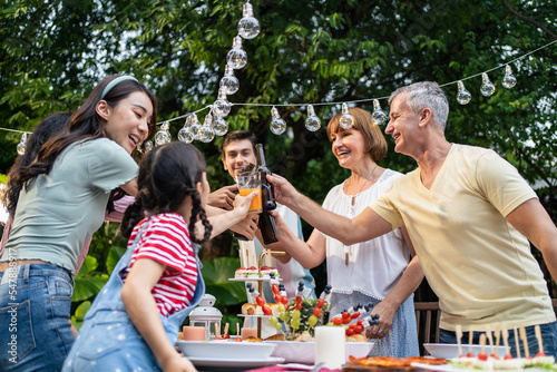 Multi-ethnic big family having fun, enjoy party outdoors in the garden. 