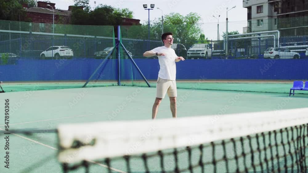 4K. A young man is warming up on the tennis court.