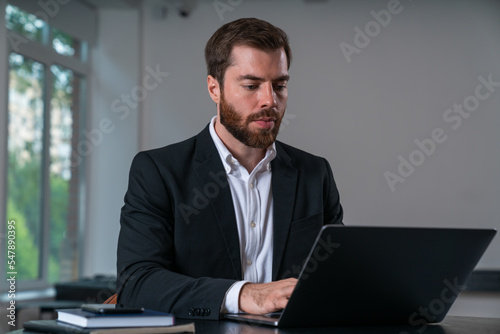 Serious businessman in formal wear working on laptop © VideoFlow