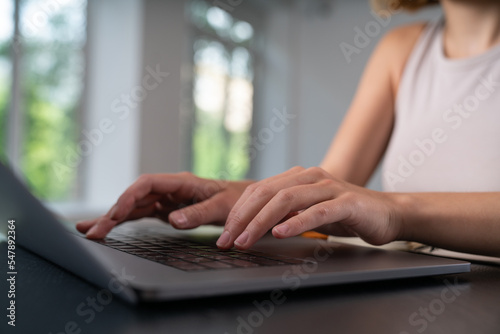 Businesswoman is sitting typing on laptop at office workplace