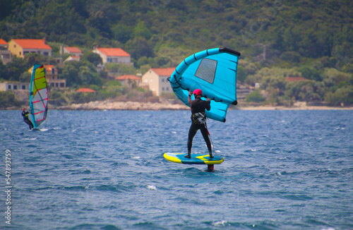 Windsurfing with wing and foilboard  at the Adriatic Sea between islands Peljesac and Korcula, Croatia