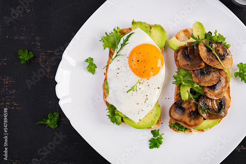 Sandwiches  with avocado, fried egg and mushrooms  for healthy breakfast or snack. Top view, above