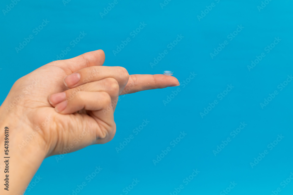 Girl holding an eye contact lens on her finger, optical advertising shot Girl holding an eye contact lens on her finger, optical advertising shot