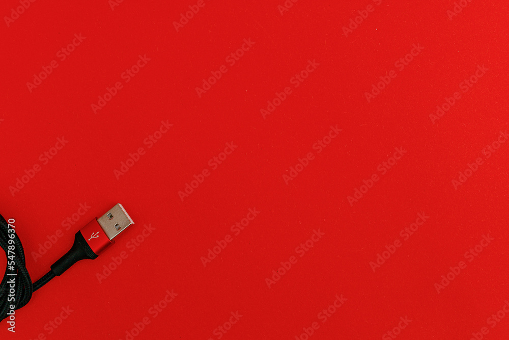 Black usb cord on red background, subject technology Black usb cord on red background, subject technology