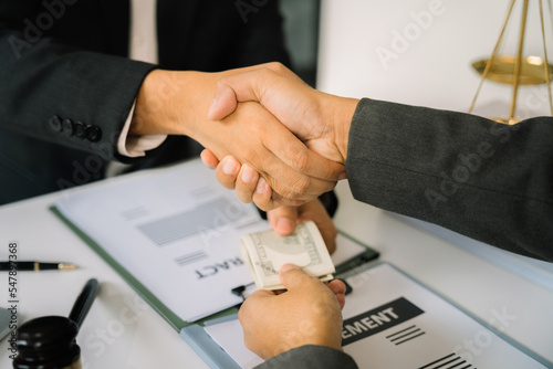 Photography Businessman giving bribe money in the envelope to partner in a corruption scam in office