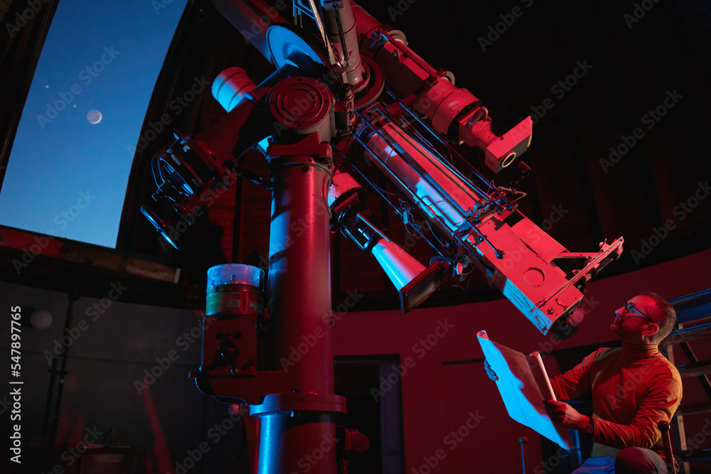 Astronomer with a big astronomical telescope in observatory doing science research. - obrazy, fototapety, plakaty 