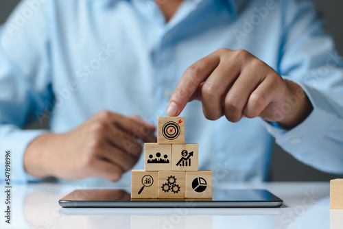 Business success goals Concept. Business man planning business operations. set business goals, use wooden blocks to plan, set goals for future success, use wooden blocks to create ideas, set target.