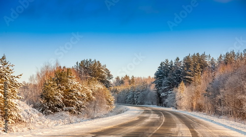 Winter landscape with road, trees and blue sky © Александр Коликов