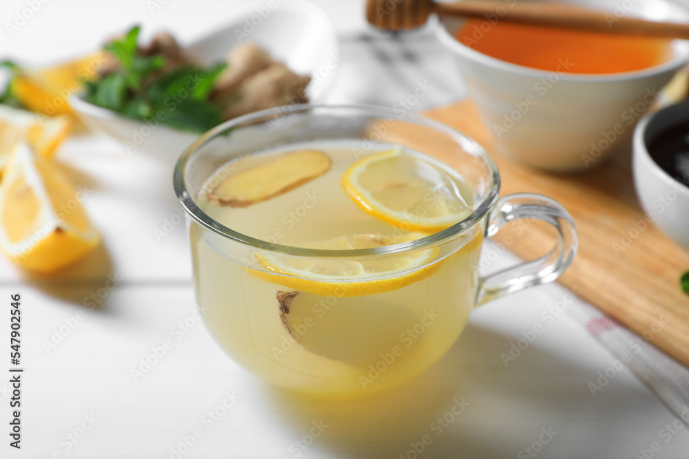 Delicious ginger tea and ingredients on white wooden table Delicious ginger tea and ingredients on white wooden table