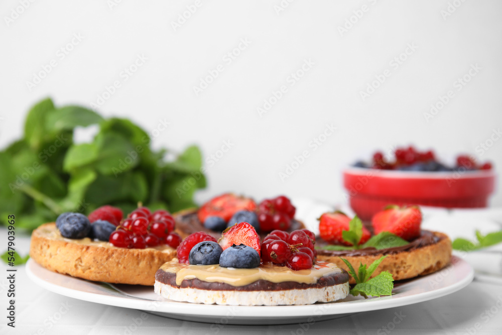 Fresh rice cake and rusks with different toppings served on white table, closeup Fresh rice cake and rusks with different toppings served on white table, closeup