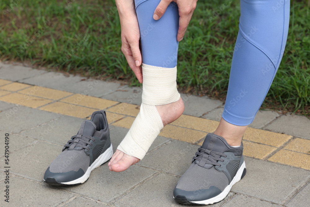 Woman with foot wrapped in medical bandage on outdoors, closeup