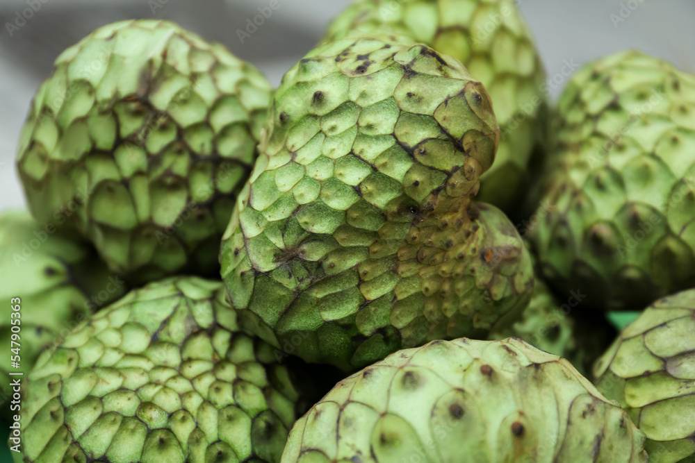 Fototapeta premium Delicious green cherimoya fruits on market stall, closeup