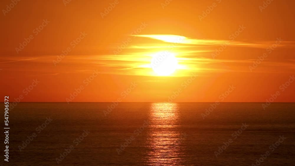 Beautiful sun behind dramatic orange clouds in sunset sky over ocean. Timelapse. Cascais Beautiful sun behind dramatic orange clouds in sunset sky over ocean. Timelapse. Cascais