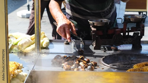 Peddler of chestnuts in Istanbul, man hand puts chestnuts in the package, street flavor idea, traditional food in Turkey, shopping from peddler, 4k 60 fps video of local seller