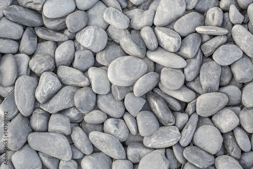 small smooth waterworn black pebbles or stones for use decor and garden landscaping. tone garden interiors. stone spa