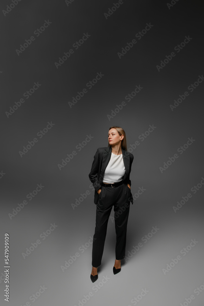 middle aged woman in office suit in studio with gray background