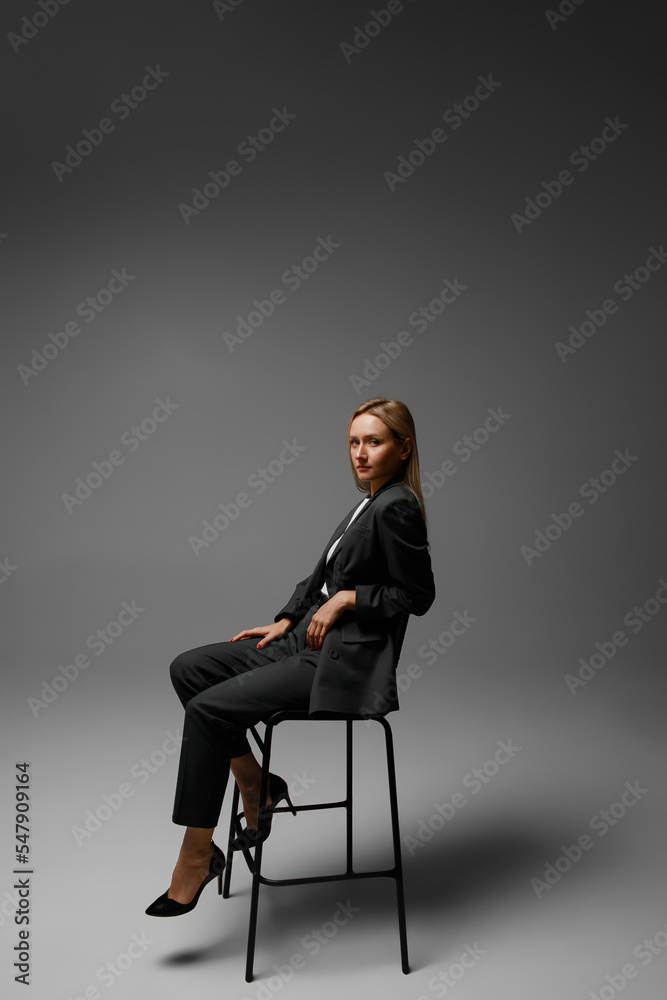 middle aged woman in office suit in studio with gray background middle aged woman in office suit in studio with gray background