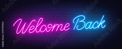 Welcome Back neon quote on brick wall background.