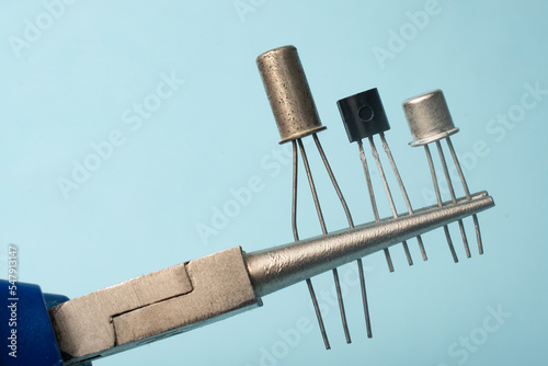 Photos Precision pliers grips three different types of transistors