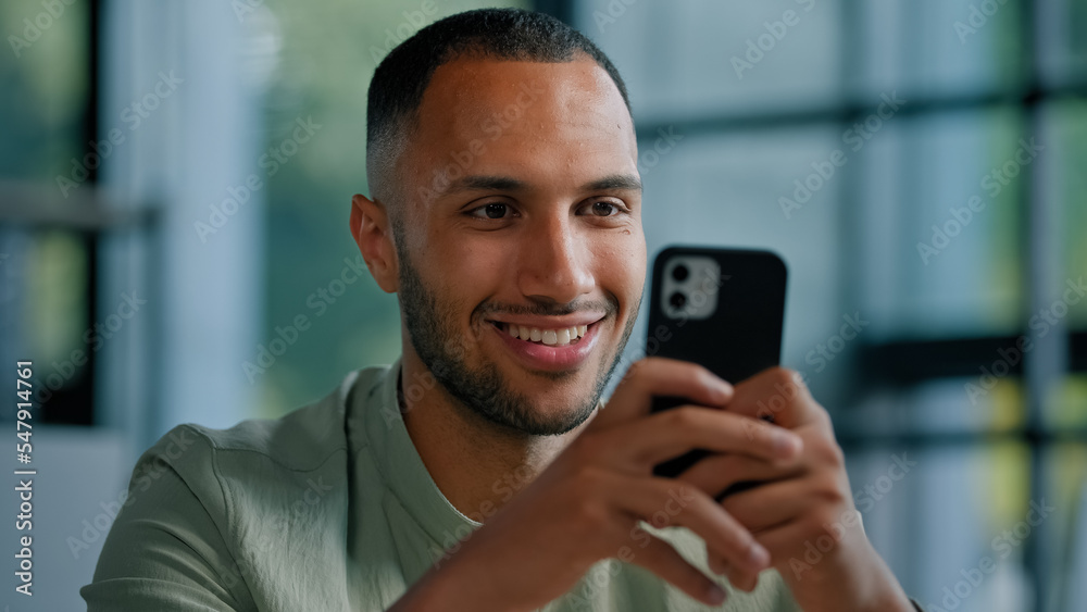 African American businessman browsing smartphone indoors. Multiracial man in office using mobile phone app networking male employer entrepreneur chatting with internet website searching net online African American businessman browsing smartphone indoors. Multiracial man in office using mobile phone app networking male employer entrepreneur chatting with internet website searching net online