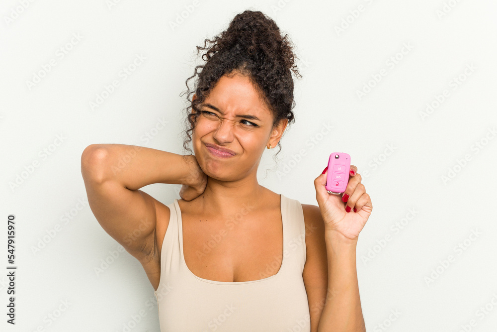 Young brazilian woman holding home keys isolated touching back of head, thinking and making a choice.