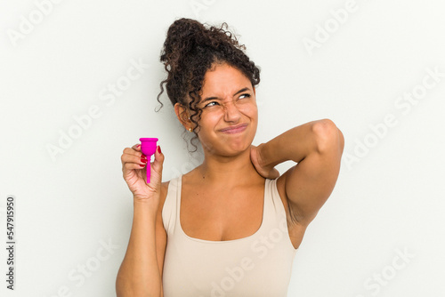 Young brazilian woman holding a menstrual cup isolated touching back of head, thinking and making a choice. photo