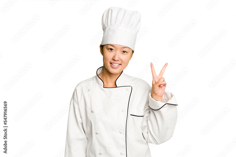 Young asian cook woman isolated joyful and carefree showing a peace symbol with fingers. Young asian cook woman isolated joyful and carefree showing a peace symbol with fingers.