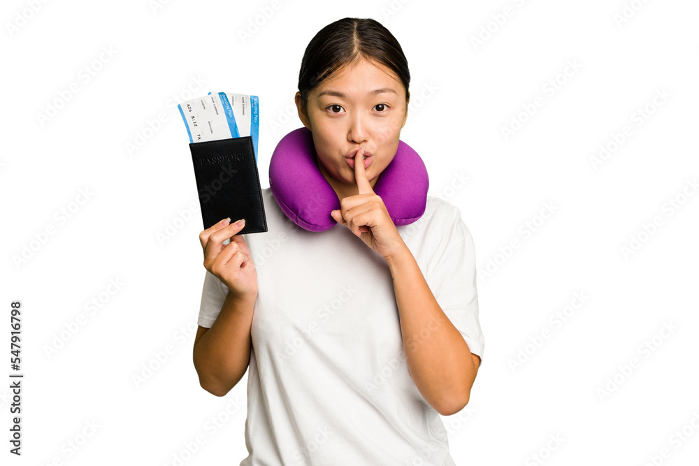 Young asian woman with inflatable travel pillow on her neck holding passport isolated keeping a secret or asking for silence. Young asian woman with inflatable travel pillow on her neck holding passport isolated keeping a secret or asking for silence.