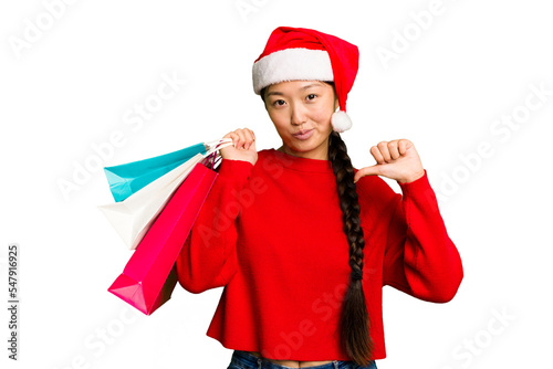 Young asian woman shopping a christmas presents isolated Young asian woman shopping a christmas presents isolated feels proud and self confident, example to follow.