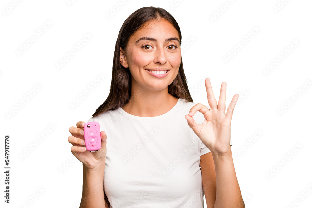 Young caucasian woman holding a car keys isolated cheerful and confident showing ok gesture. Young caucasian woman holding a car keys isolated cheerful and confident showing ok gesture.