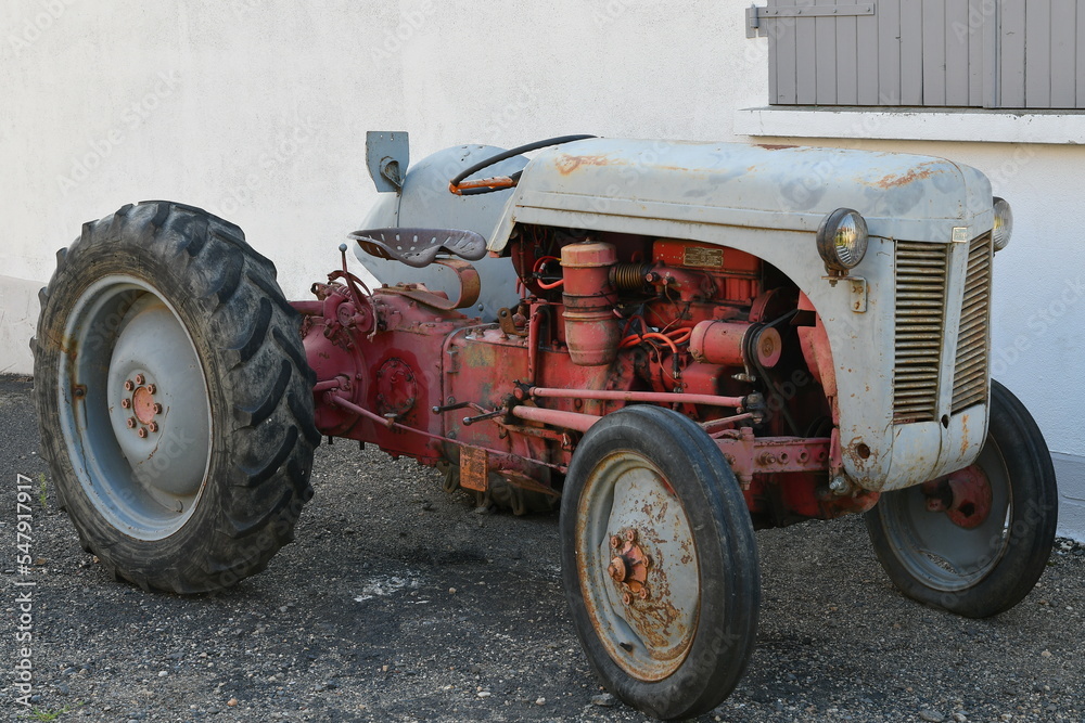 tracteur rouge ancien en état de marche devant une maison dans un petit village du puy de dôme tracteur rouge ancien en état de marche devant une maison dans un petit village du puy de dôme