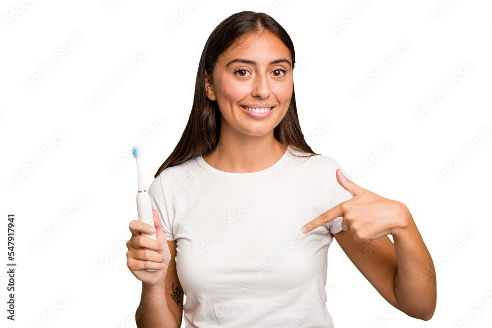 Young caucasian woman holding an electric toothbrush isolated person pointing by hand to a shirt copy space, proud and confident Young caucasian woman holding an electric toothbrush isolated person pointing by hand to a shirt copy space, proud and confident