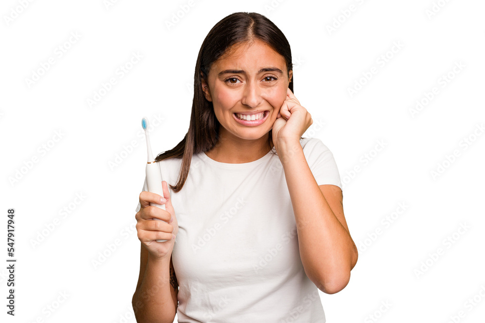 Young caucasian woman holding an electric toothbrush isolated covering ears with hands. Young caucasian woman holding an electric toothbrush isolated covering ears with hands.