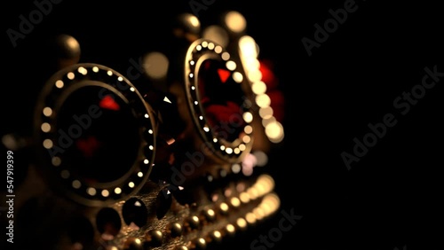 Golden crown with rubies on black background 3D 4K looped animation with copy space. Sparkling royal corona. Close-up.