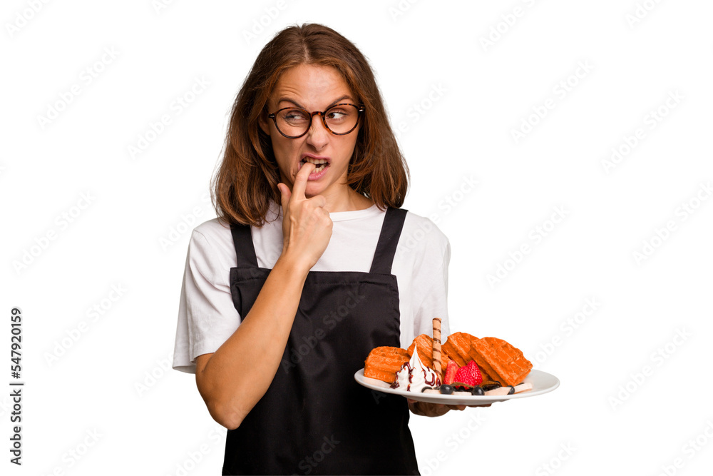 Young caucasian woman holding a waffles dish isolated relaxed thinking about something looking at a copy space. Young caucasian woman holding a waffles dish isolated relaxed thinking about something looking at a copy space.
