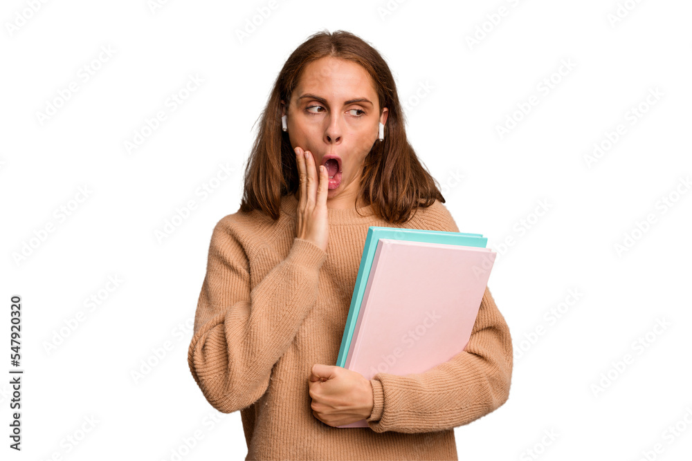Young student woman holding a books isolated is saying a secret hot braking news and looking aside Young student woman holding a books isolated is saying a secret hot braking news and looking aside