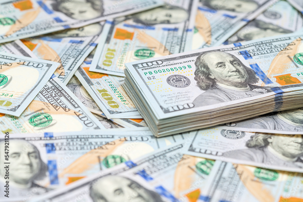 Stack of 100 dollars bills on a money background. American cash. Finance and economy concepts. Stack of 100 dollars bills on a money background. American cash. Finance and economy concepts.