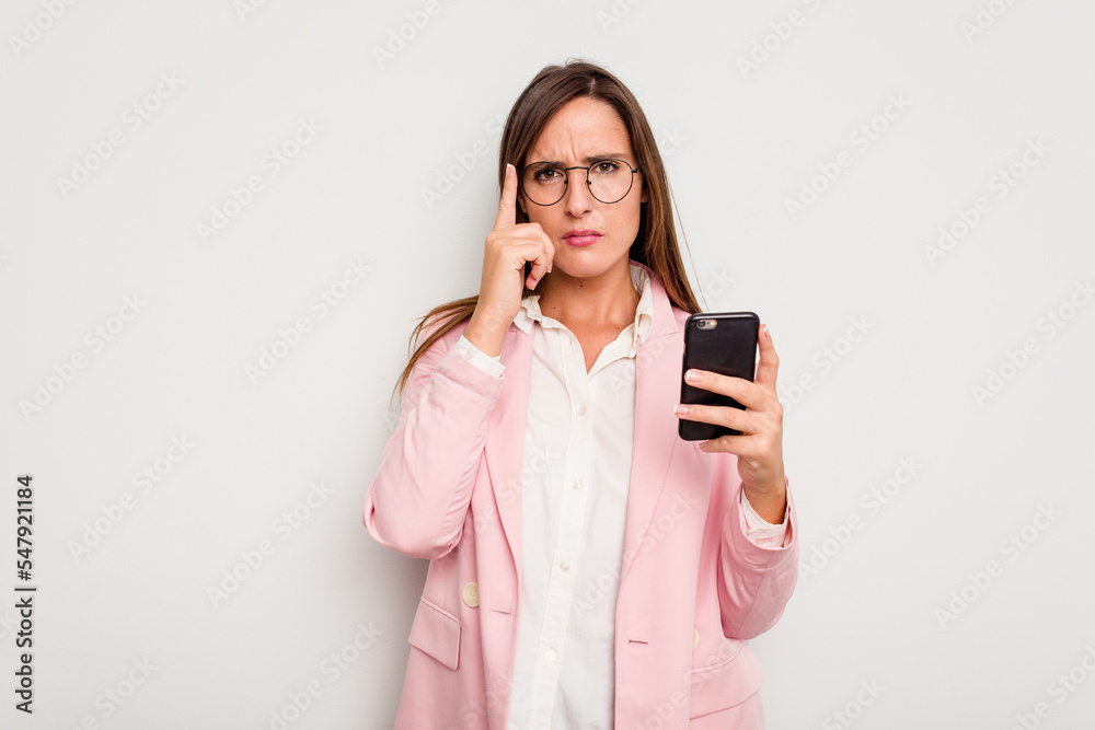 Business caucasian woman holding a mobile phone isolated on white background pointing temple with finger, thinking, focused on a task. Business caucasian woman holding a mobile phone isolated on white background pointing temple with finger, thinking, focused on a task.