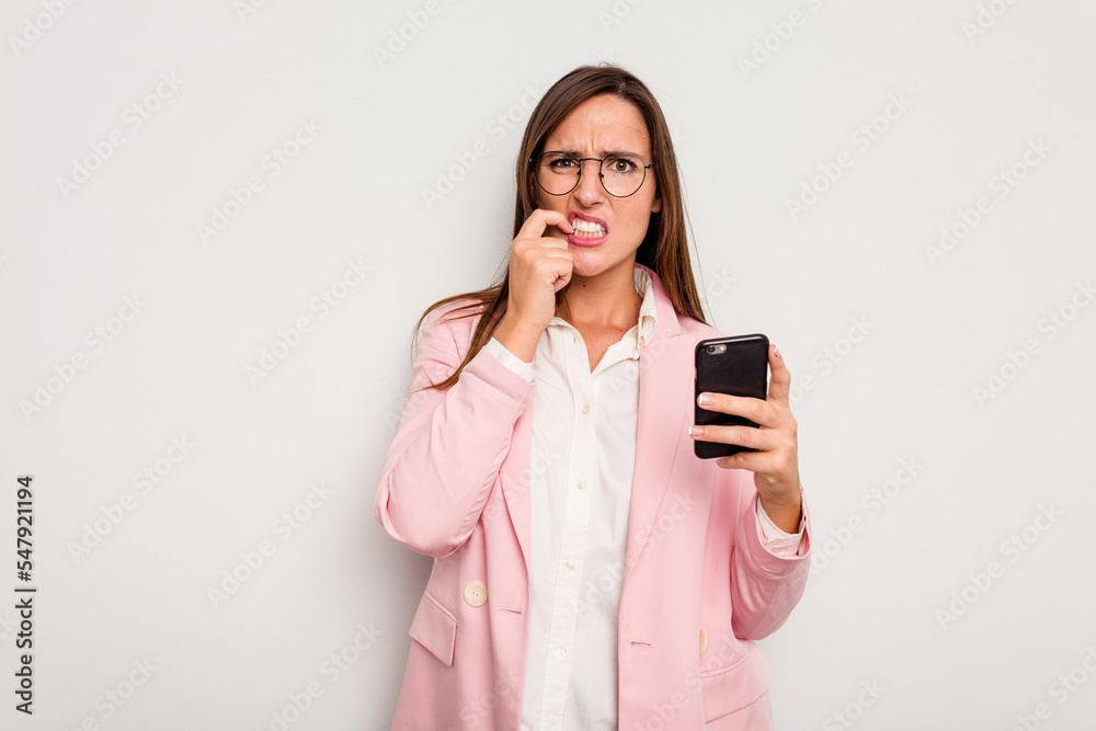 Business caucasian woman holding a mobile phone isolated on white background biting fingernails, nervous and very anxious. Business caucasian woman holding a mobile phone isolated on white background biting fingernails, nervous and very anxious.