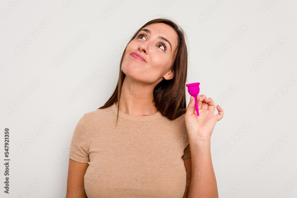 Young caucasian woman holding menstrual cup isolated on white background dreaming of achieving goals and purposes Young caucasian woman holding menstrual cup isolated on white background dreaming of achieving goals and purposes