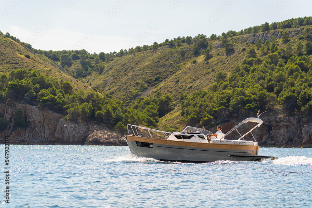 Little luxury boat sailing near the line coast
